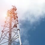 A telecom towers on a bright blue-sky day.