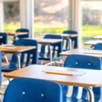 A row of desks in a clean classroom