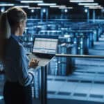 A woman standing in a large data center with cooling systems