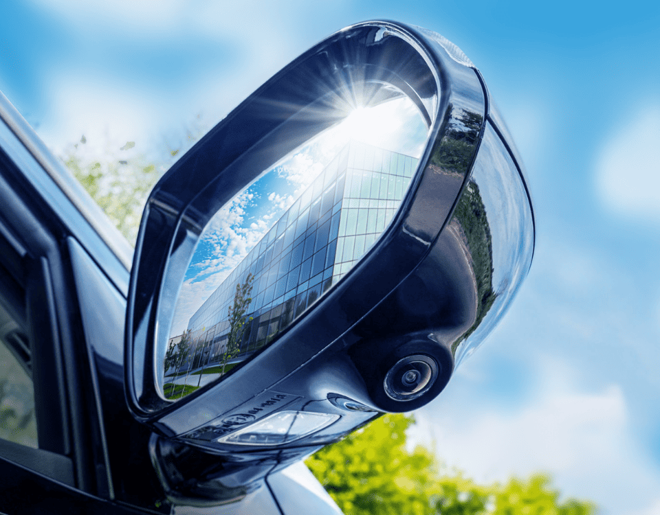 A close-up of an electric vehicle side mirror reflecting a high-tech data center.